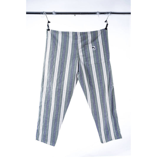A pair of striped cropped pants in gray, white, and green, hanging from a black metal clothesline against a white background. A small white brand patch is visible on the back pocket.