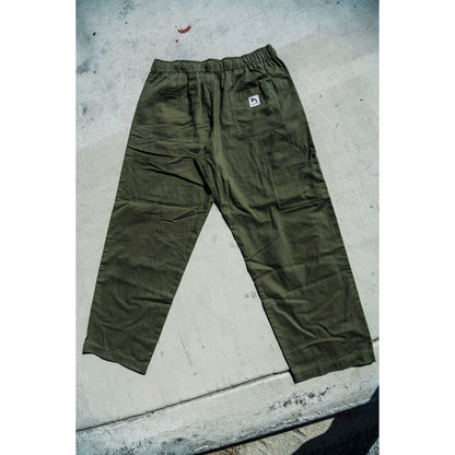 olive green baggy skate pants on a concrete surface