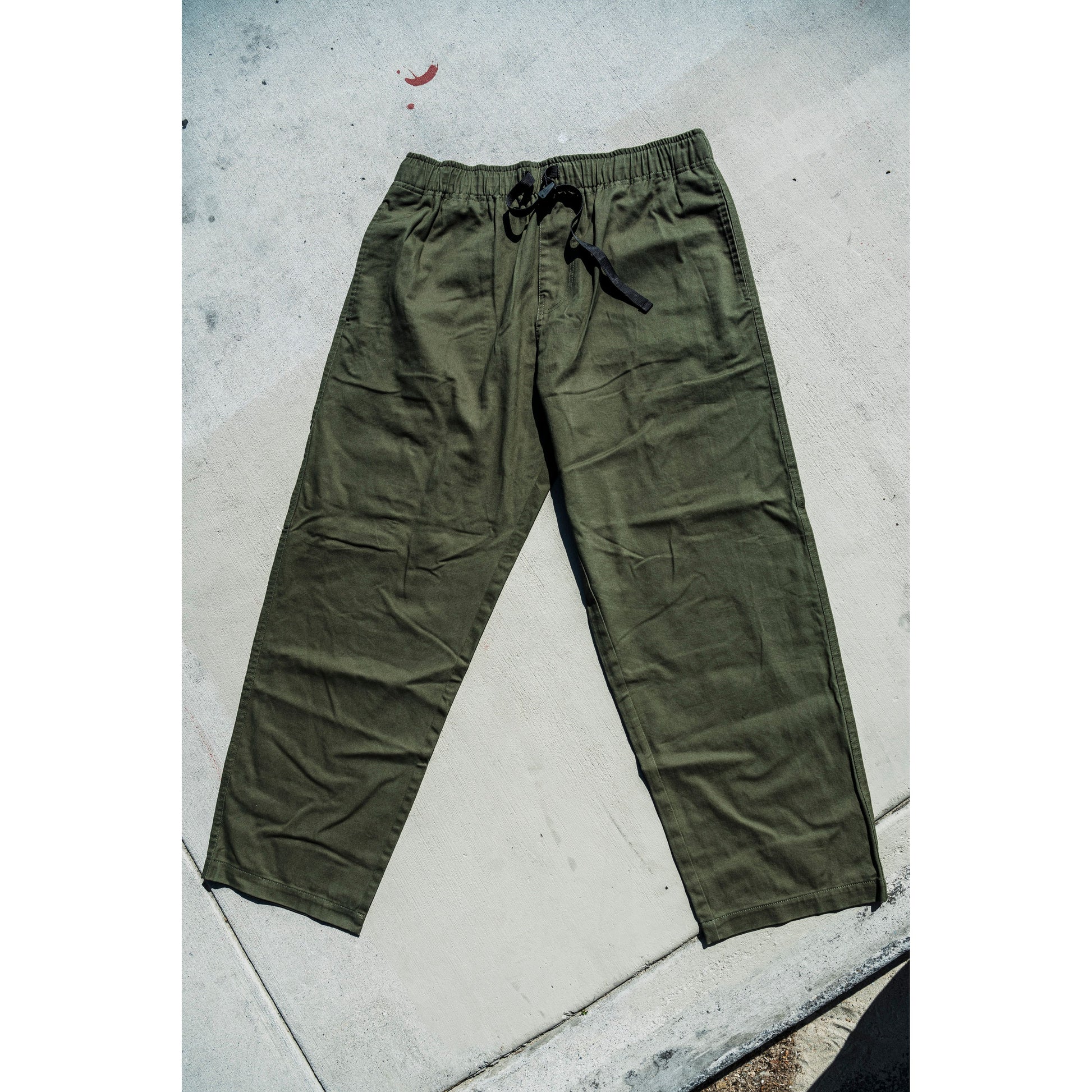 olive Green baggy skate pants on a concrete floor