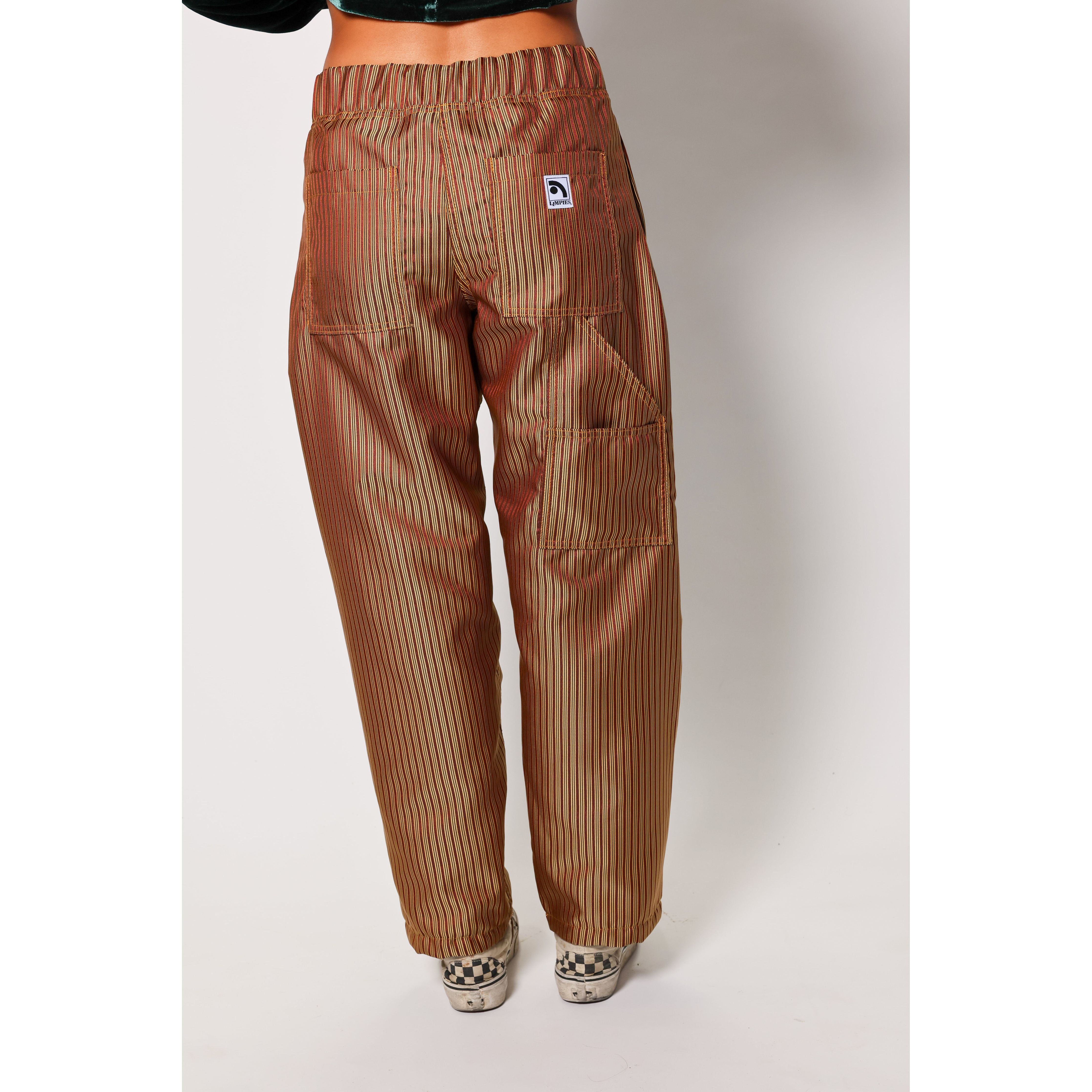 Baggy skate pants in burgundy with a gold stripe. These retro striped skate pants offer a bold 90s street style and a perfect baggy fit for the streets. Made in USA.