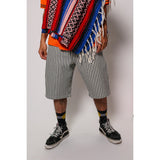 "Over the Knee" skate shorts with a Hickory stripe pattern. The wide cut that recalls retro jorts style and 90s baggy skatewear, maintaining authenticity and urban flow.