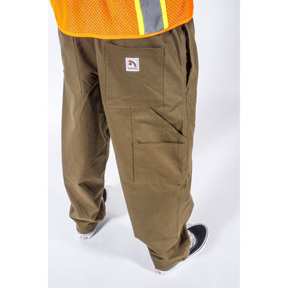 A person wearing brown work pants with multiple cargo pockets, shown from the waist down. The pants have a small square logo patch on the back pocket.