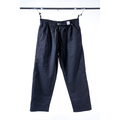 Black wide-leg baggy skate pants with an elastic waistband, hanging from clips on a metal bar against a white background.