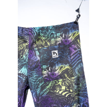 Close-up of a pair of Limpies baggy skate pants hanging from a black clip against a white background. The pants feature a highly detailed, colorful graphic print with purple, teal, green, and yellow elements, and a small white Limpies brand patch on the front pocket.