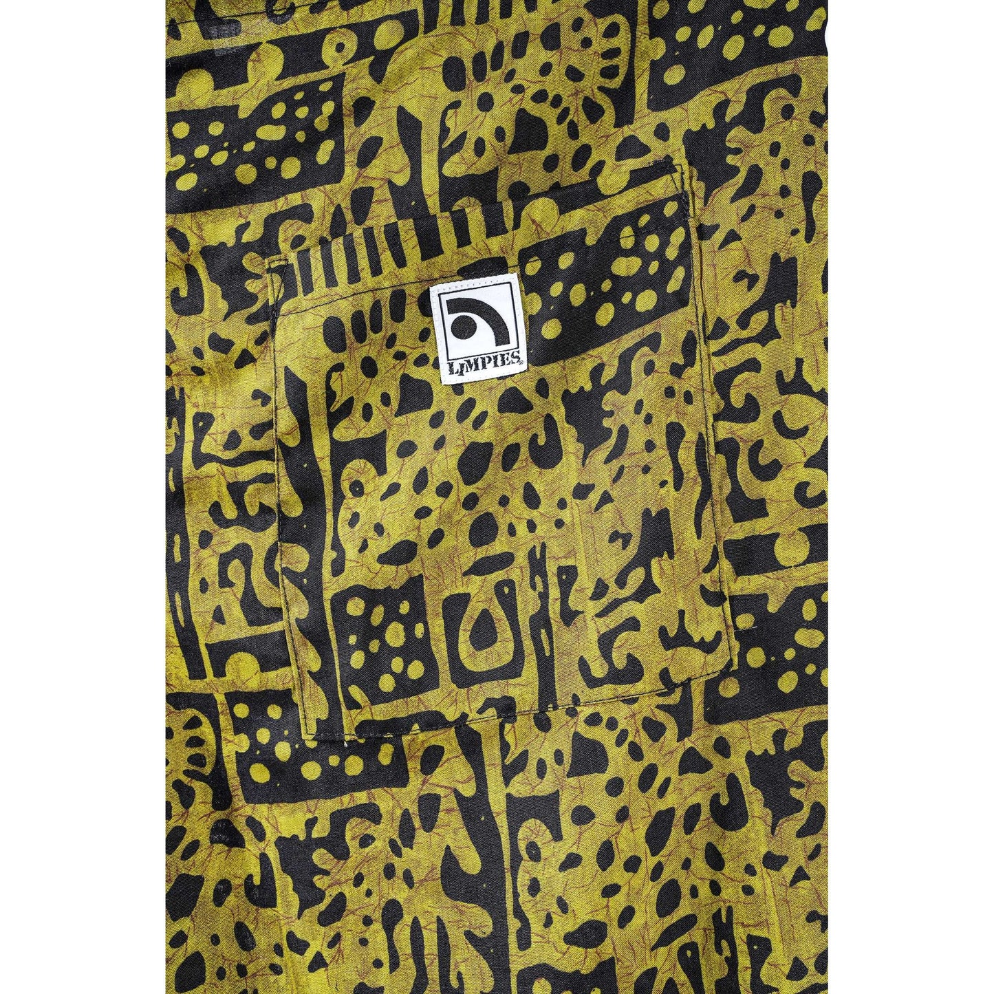 Close-up of a yellow and black patterned  Limpies baggy skate shorts, featuring a front pocket with a white square patch that reads 'Limpies'.