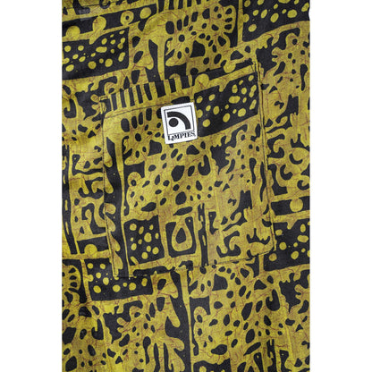 Close-up of a yellow and black patterned  Limpies baggy skate shorts, featuring a front pocket with a white square patch that reads 'Limpies'.