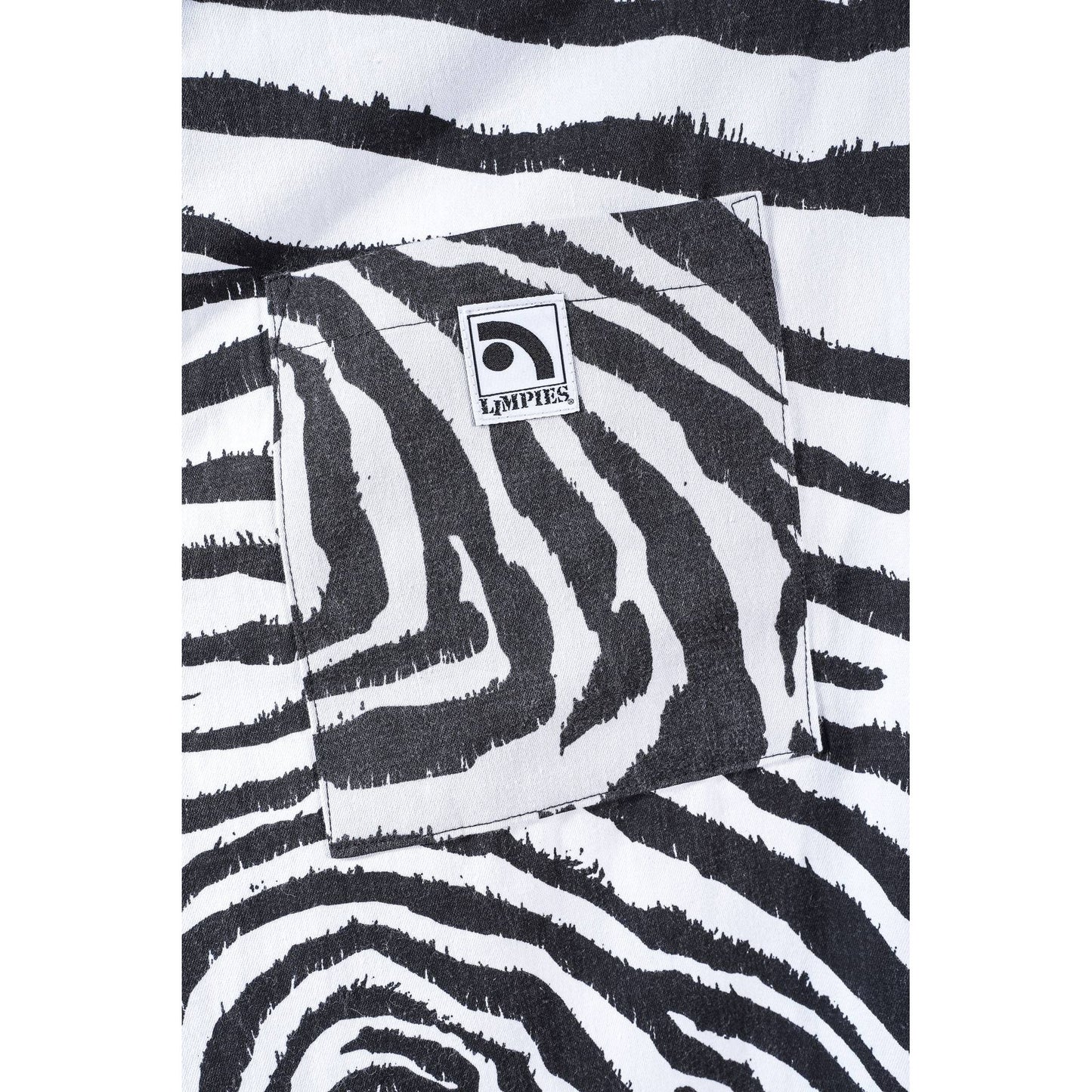 Close-up of a black and white zebra print baggy skate pants with a square pocket and a visible Limpies logo patch.