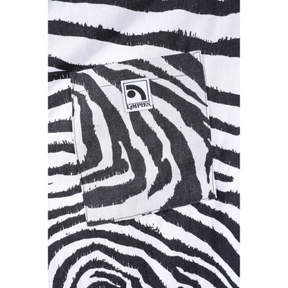 Close-up of a black and white zebra print baggy skate pants with a square pocket and a visible Limpies logo patch.