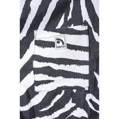 Close-up of black and white zebra-print baggy skate shorts featuring a front pocket with a visible square patch logo that reads 'Limpies'.